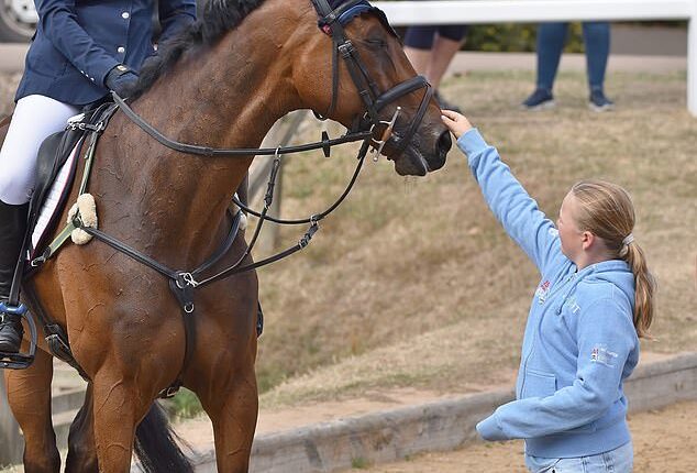Mia Tindall is pictured petting her mother Zara's horse Showtime, while attending the Horse Trials at Hartpury in Gloucestershire on Saturday