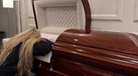 Erike Kirk, the wife of the late Charlie Kirk, appears to be collapsed in grief as she lies draped across her husband's casket