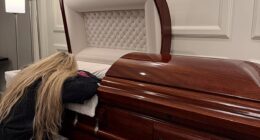 Erike Kirk, the wife of the late Charlie Kirk, appears to be collapsed in grief as she lies draped across her husband's casket