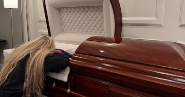 Erike Kirk, the wife of the late Charlie Kirk, appears to be collapsed in grief as she lies draped across her husband's casket