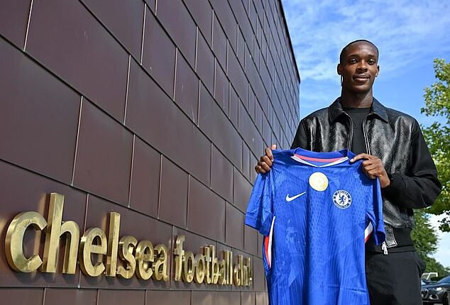 Emanuel Emegha poses with a Chelsea shirt at their Cobham training ground