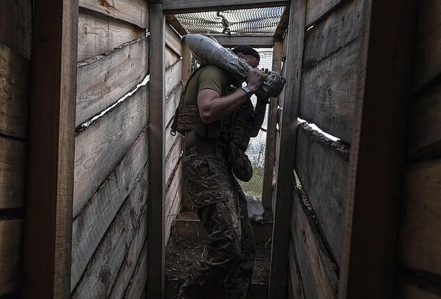 A soldier carries a shell to fire towards positions of Russian troops near Kostyantynivka in Donetsk region, Ukraine, Tuesday, Aug. 26, 2025