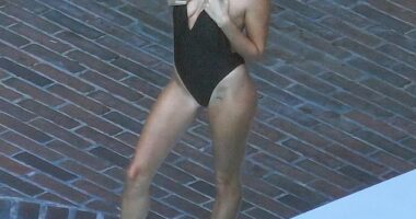 Hailey Bieber looked nothing short of sensational while modeling a plunging black swimsuit during a poolside photoshoot at the Chateau Marmont in West Hollywood