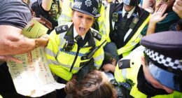 A demonstrator is led away by police officers as people take part in a protest in support of Palestine Action in Parliament Square on Saturday