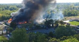 Multiple people have been shot at a church in Michigan. The church was set on fire amid the horror, as shown above in a drone shot from the scene on Sunday morning