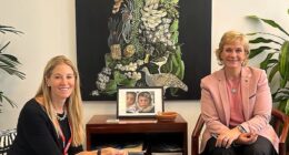 Zali Steggall (right) sitting in front of 'Zali as Flora', which hangs inside her Canberra office