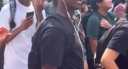 A Texas State University student (front, in black t-shirt) has been expelled after he repeatedly reenacted Charlie Kirk's assassination at an on-campus memorial