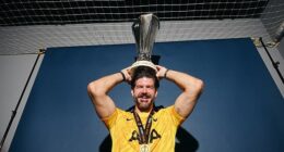 Fraser Forster poses with the Europa League trophy after last season's Tottenham triumph