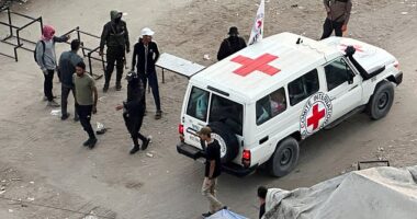 A Red Cross vehicle moves along a road before the expected release of hostages held in Gaza