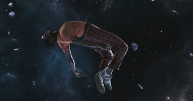 Ncuti Gatwa as the Fifteenth Doctor in tartan trousers and an orange top unconscious and floating in space