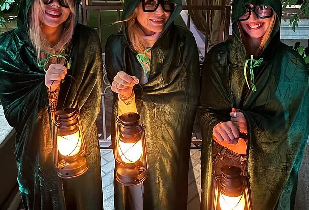 Amanda Holden and her lookalike daughters Lexi, 19, (left) and Hollie, 13, (right), channelled Traitors star Alan Carr in their hooded capes for Halloween on Instagram on Friday