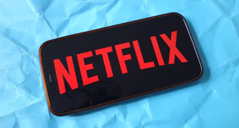 In this photo illustration, the Netflix company logo is seen...