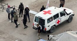 A Red Cross vehicle moves along a road before the expected release of hostages held in Gaza