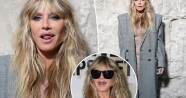 Heidi Klum wears totally see-through lace dress with platinum grill at Vetements during Paris Fashion Week