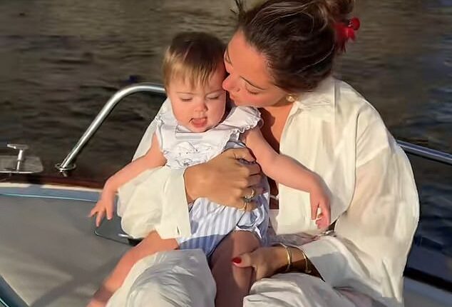 Campbell 'Pookie' Puckett with her 10-month-old daughter Paloma, nestled in Puckett's lap, sitting near the edge of the rocking boat