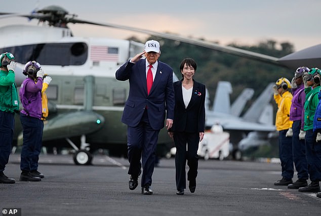 President Donald Trump and Japanese Prime Minister Sanae Takaichi walk on the USS George Washington, an aircraft carrier docked at a U.S. naval base, before speaking to members of the military, in Yokosuka, Tokyo