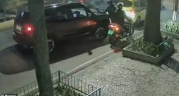 This is the moment an armoured Jeep driver rams into two armed robbers trapping them beneath her vehicle after they tried to hold her up in the street. Pictured: The attempted robbery taking place