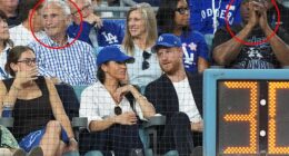 Prince Harry and Meghan Markle were sat in front of Sandy Koufax (L) and Magic Johnson (R)