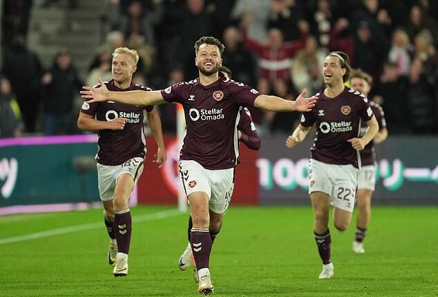 Craig Halkett races off, arms outstretched, after helping his side claim all three points