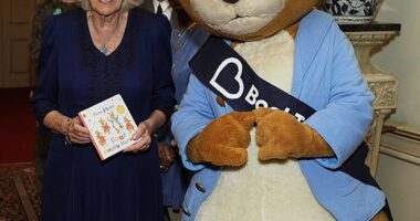 Queen Camilla is pictured beaming next to Peter Rabbit at an event at Clarence House today as she poses with the new book, Four Happy Bunnies