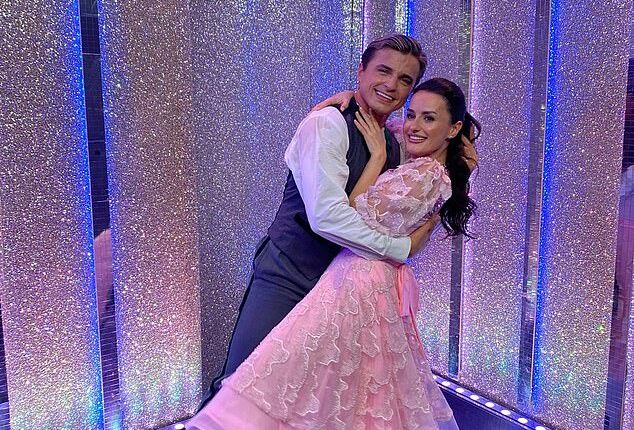 Strictly professional Nikita Kuzmin and his celebrity partner Amber Davies have 'sizzling chemistry' after he was spotted kissing her head in the street