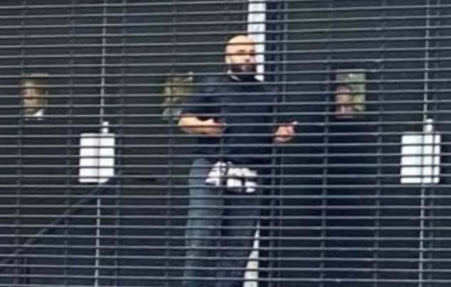 Hero worshippers can be seen in the windows behind Jihad Al-Shamie as they barricaded the doors at Heaton Park Synagogue before police opened fire