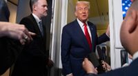 Donald Trump speaks with reporters aboard Air Force One as U.S. Trade Representative Jamieson Greer, left, listens, shortly after taking off from Busan, South Korea, en route to Joint Base Andrews, on Thursday