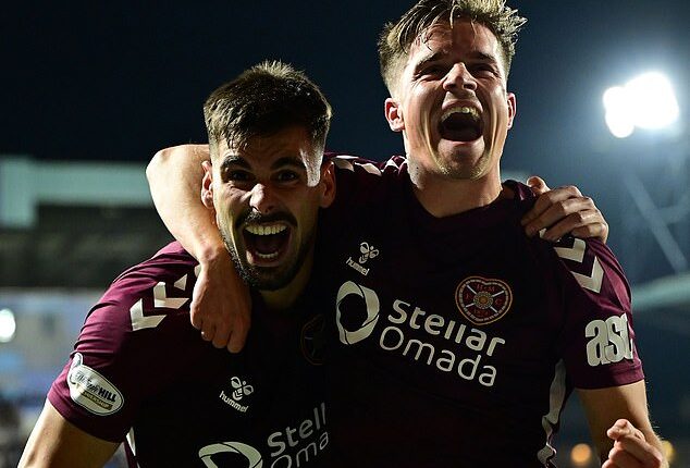 Braga and Devlin (right) celebrate after the striker put Hearts 2-0 ahead