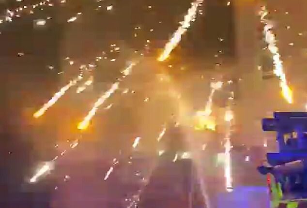 Emergency services duck for cover as fireworks explode overhead in Liverpool on Bonfire Night after being thrown by thugs