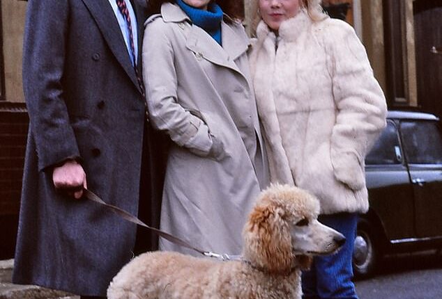 Original EastEnders characters Den Watts (played by Leslie Grantham), Angie Watts (Anita Dobson) and daughter Sharon (played by Letitia Dean) with Roly the dog outside the Queen Vic