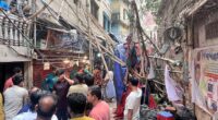 Residents stand in an alley after vacating their house next to a fallen scaffolding following an earthquake in Dhaka, Bangladesh, November 21, 2025