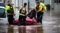 Emergency services help people stricken on a flooded street on November 15 in Monmouth, Wales