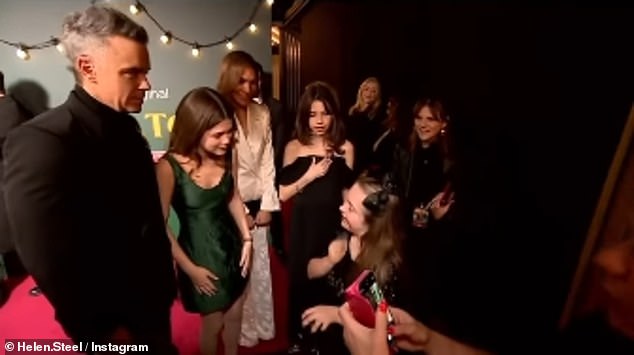 Robbie Williams' daughter, Teddy, shared a sweet moment with a fan and parent at the London premiere of her Christmas movie, Tinsel Town, on Thursday (pictured with fan Connie)