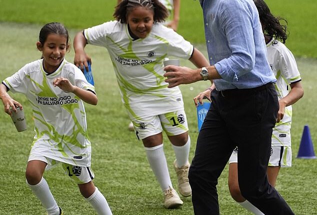 Sweet moment Prince William plays football with local children and meets Brazilian football legend Cafu during visit to iconic Maracana stadium in Rio de Janeiro