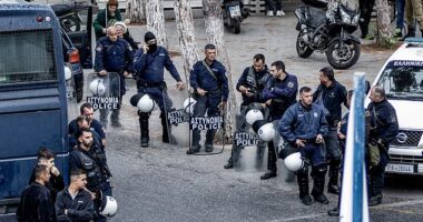A 56-year-old woman was one of two people shot dead during a dramatic gunfight in a Cretan mountain village on Saturday. Pictured: Armed police stand guard following the incident