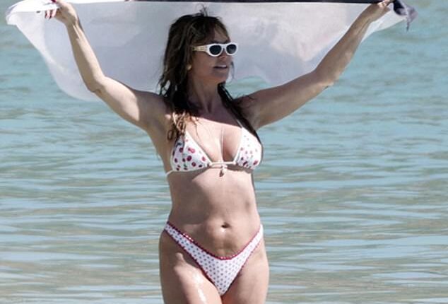 Heidi Klum, 52, dried off with a towel emblazoned with husband Tom Kaulitz's face as they hit the beach amid their sun-soaked festive getaway to St. Barths on Sunday