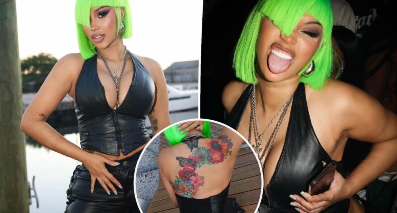 Cardi B shows off new neck and back dermal piercings in plunging second-skin leather look