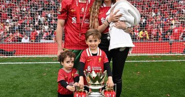 Jota is pictured at Anfield with the Premier League trophy alongside his partner, Rute Cardoso, and their three children after helping Liverpool secure their 20th league title last season