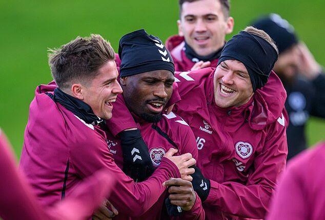 Cammy Devlin, Elton Kabangu and Blair Spittal share a joke in Hearts training