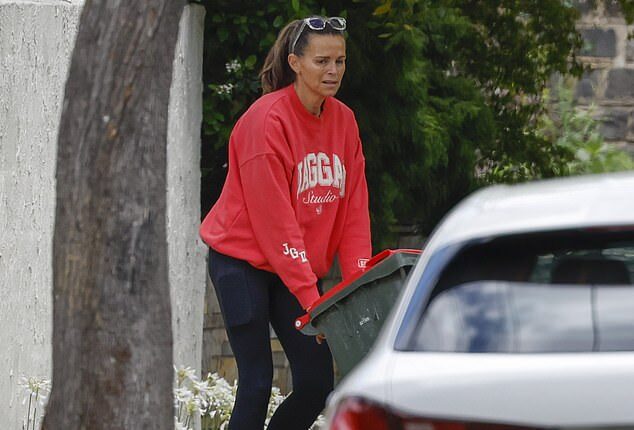 Jo Silvagni takes out the trash outside a home owned by a Melbourne lawyer
