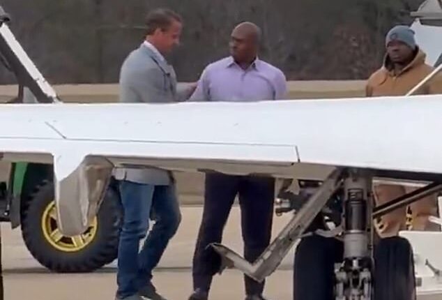 Lane Kiffin (left) was seen leaving a chauffeured SUV and walking across the tarmac to his waiting plane as hundreds of his former supporters offered a chorus of boos and expletives