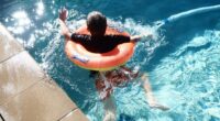 boy with floatie swims in pool