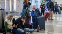Pictured: People wait for their flight at LaGuardia Airport in Queens, New York, on Friday as a winter storm tears through the Northeast