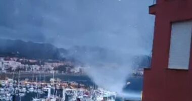 A waterspout was seen in footage tearing through a port in a Spanish holiday resort after flooding left at least one person dead