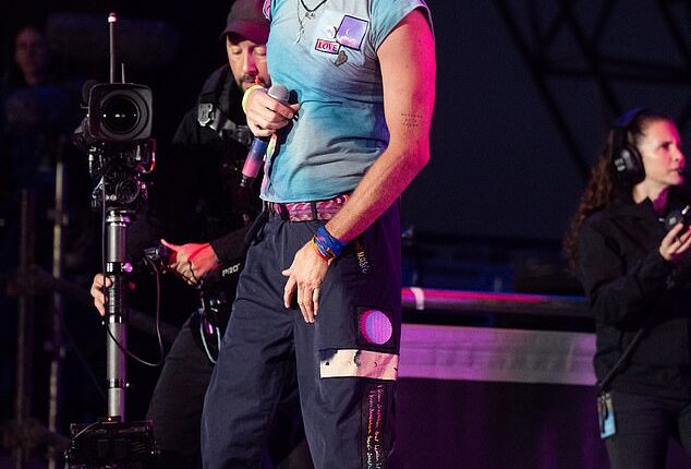 Chris Martin wearing one of his signature tie-dyed t-shirts for his performance at Glastonbury in summer 2024