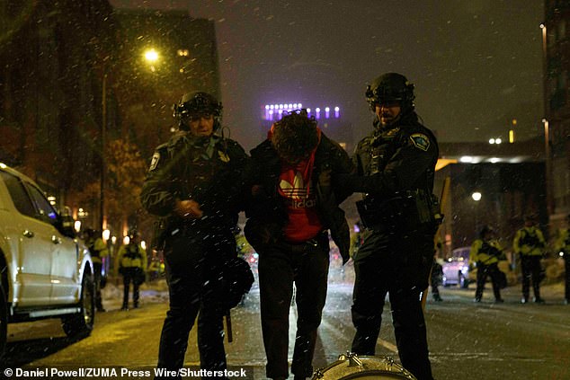 An anti-ICE protester is arrested during a late night protest in Minneapolis