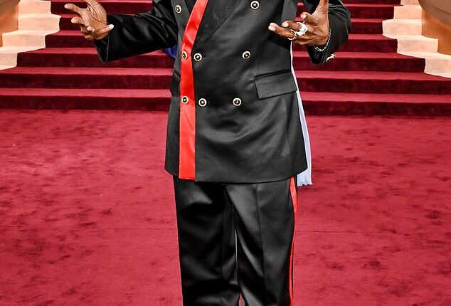 Pajama vibes! Snoop Dogg looked like he was going to an entirely different even as he sported a black satin suit on the Globes red carpet. The suit featured red stripe detailing on the blazer and side of his pants. He completed the look with a shiny black pair of dress shoes