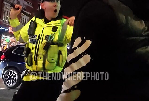 A police officer faces off with a man during clashes in Manchester this week as members of the Kurdish community protested events in Syria