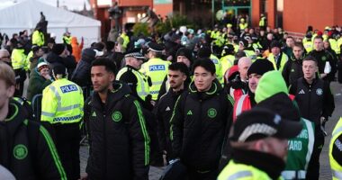 Police line up around the Celtic players as they exit the stadium after Saturday's defeat