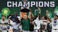 Miami head coach Mario Cristobal holds the Field Scovell Trophy following the Cotton Bowl